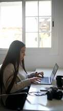 A woman working at a laptop.